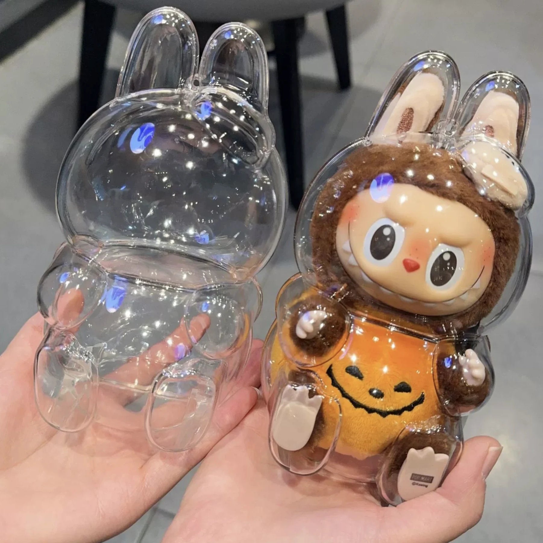 Front and back view of the clear protective case for Labubu v2 (Pop Mart Have a Seat Vinyl Plush Blind Box). High-quality PC material by FigPalace.