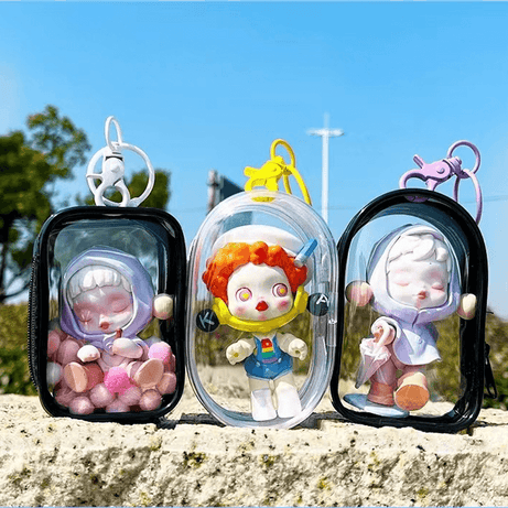Three cute Pop Mart Figures are standing on the ground, inside FigPalace Display Bags.