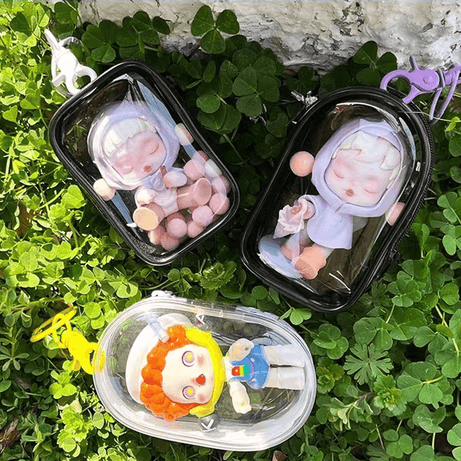 Three cute Pop Mart Figures are placing on the grassland, inside FigPalace Display Bags.