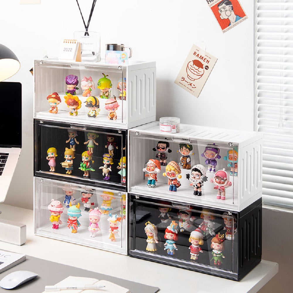 Several white and black acrylic display boxes arranged on a desk, each filled with colorful POP Mart-style collectible figurines. A reed diffuser and small decorations sit nearby.