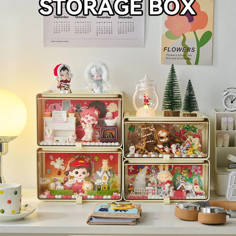 Drawer-style transparent display boxes stacked on a desk, showcasing decorative blind box figures and toys