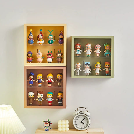 Three wall-mounted display shelves with three different colors and vinyl figurines inside.