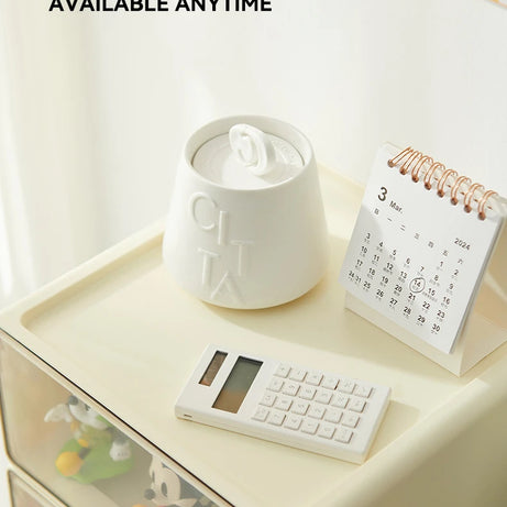 Person organizing mini figures inside a cream-colored drawer-style storage box with clear front