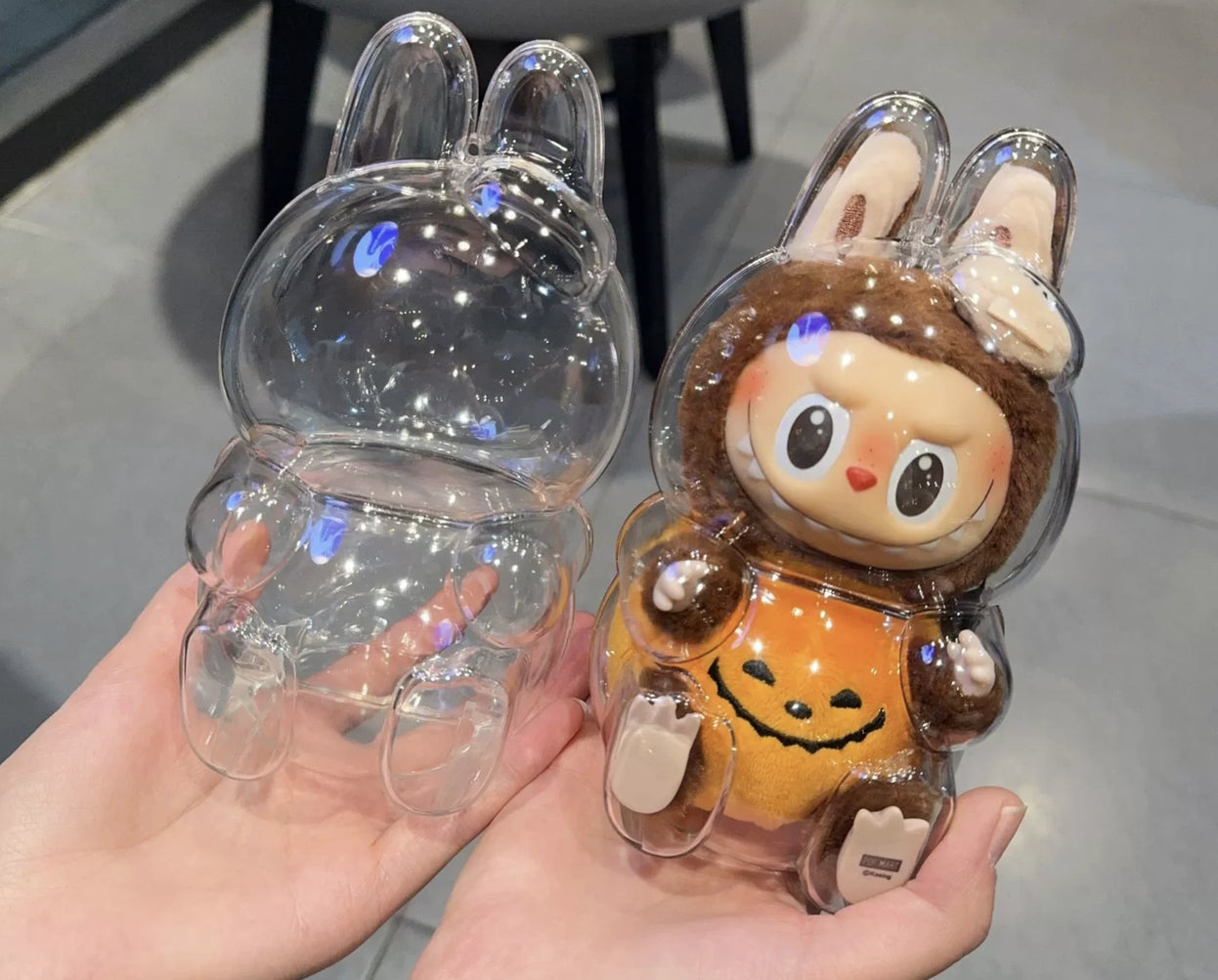 Front and back view of the clear protective case for Labubu v2 (Pop Mart Have a Seat Vinyl Plush Blind Box). High-quality PC material by FigPalace.