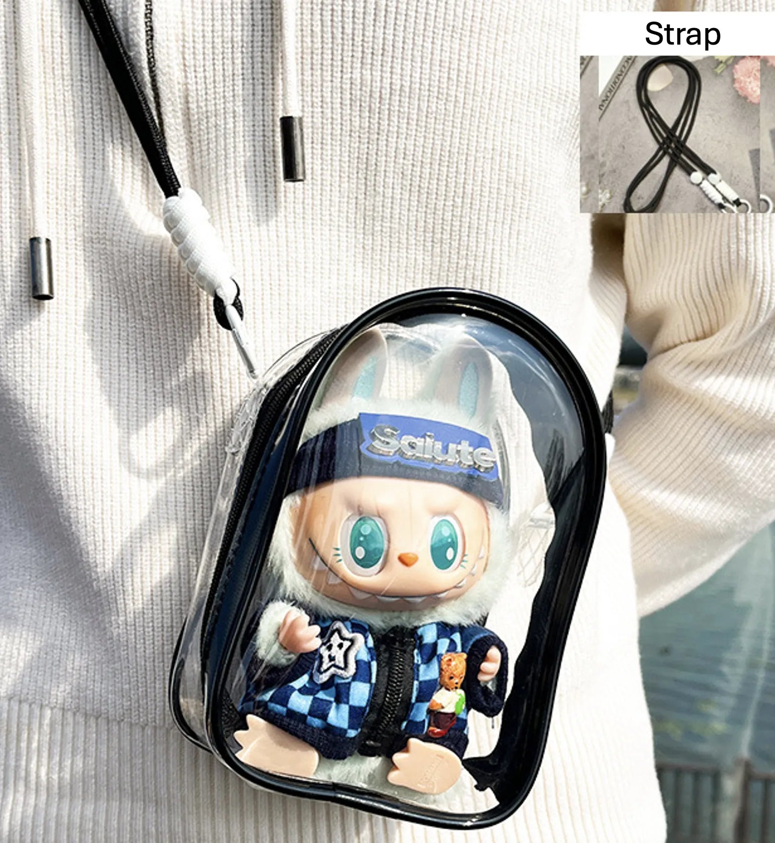 A transparent PVC display bag with a black strap, showcasing a Labubu figure in a blue checkerboard jacket. The bag is ideal for displaying Pop Mart figures while keeping them protected.