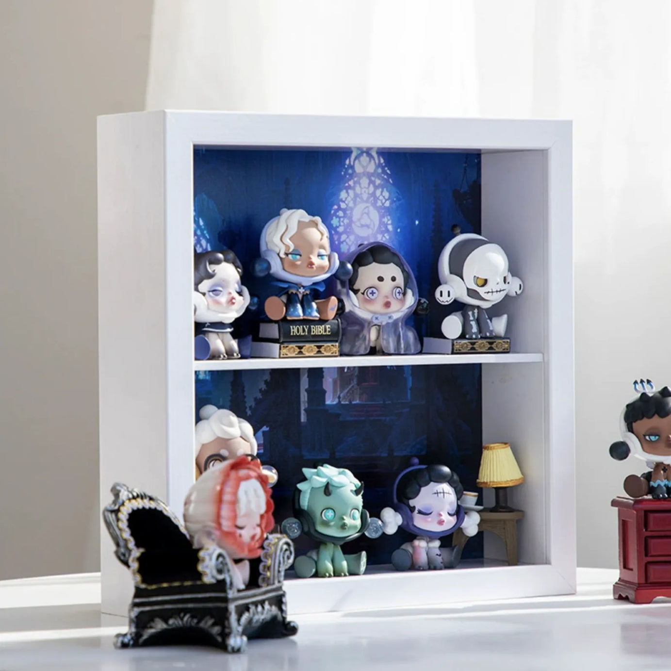 A squared white wooden display case from Fig Palace with two layers,featuring a collection of designed Skullpanda figures from Popmart, each with distinct colors and styles,neatly arranged for display.