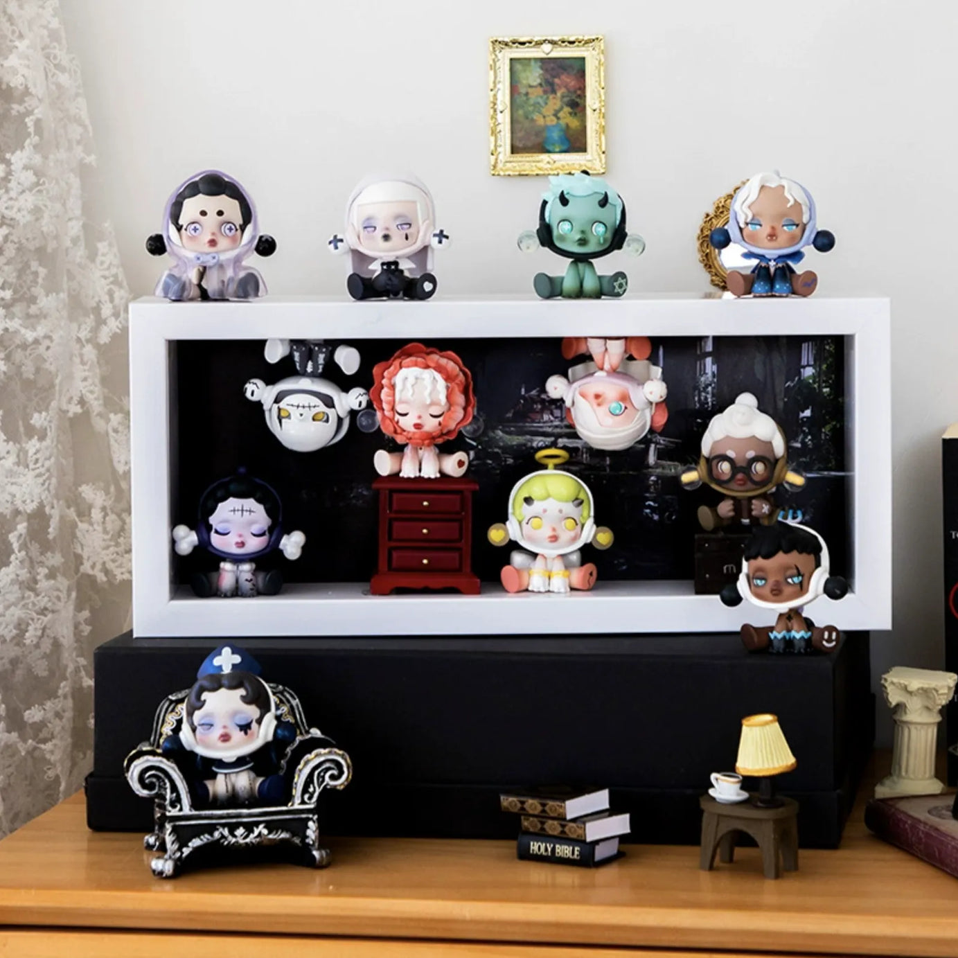 A medium-size white wooden display case from Fig Palace with one layer,featuring a collection of designed Skullpanda figures from Popmart, each with distinct colors and styles,neatly arranged for display.