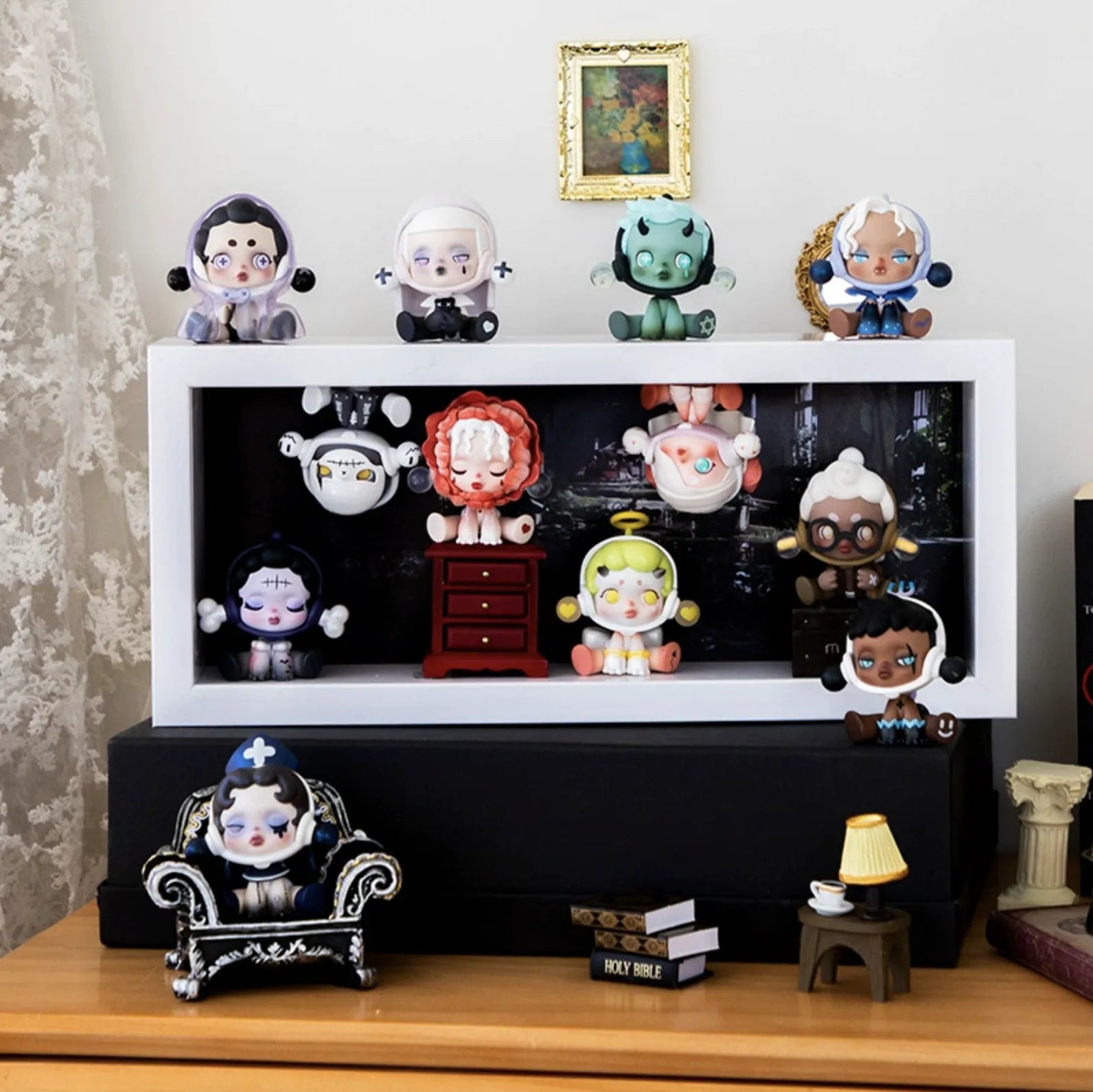 A medium-size white wooden display case from Fig Palace with one layer,featuring a collection of designed Skullpanda figures from Popmart, each with distinct colors and styles,neatly arranged for display.